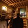 Guests with headphones watching a video in a gallery set up like a medieval dwelling